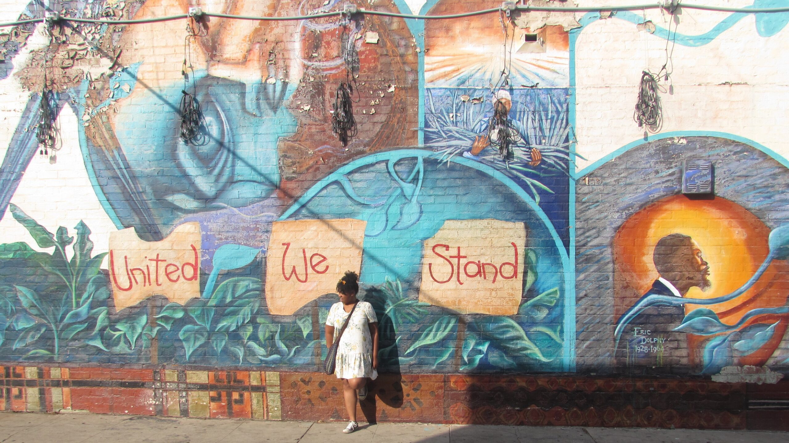woman standing in front of a colorful mural
