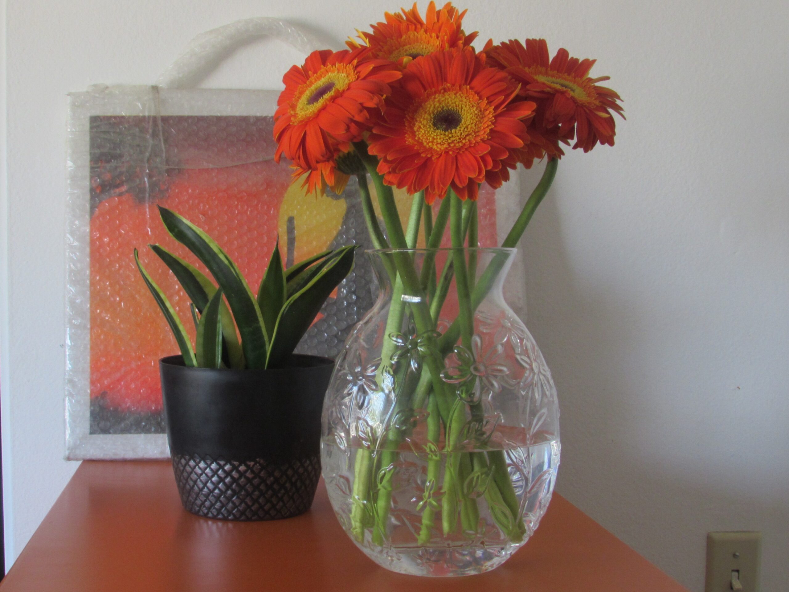 flowers and plant in front of painting