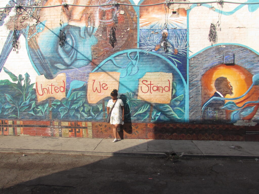 woman standing in front of a mural in Leimert Park area
