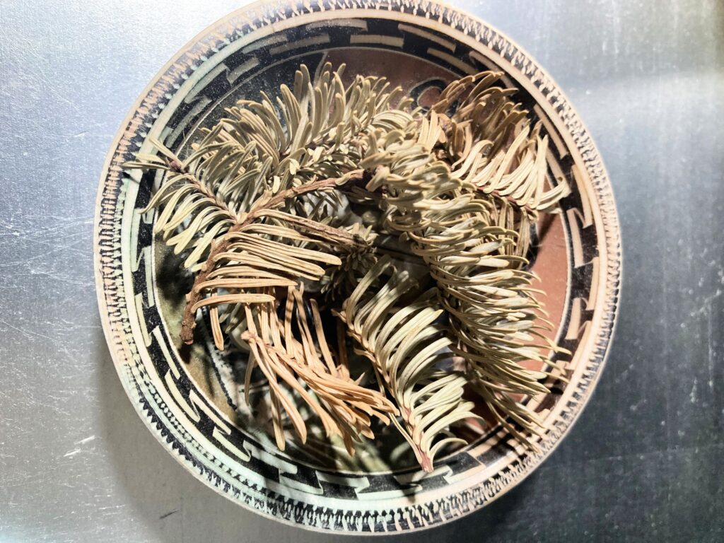 dried Christmas tree branches pieces in a dish 